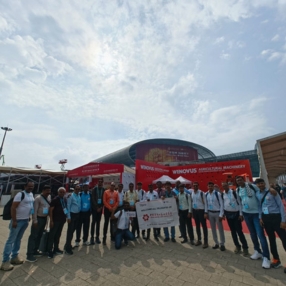 A group of people posing outside an exhibition venue