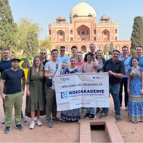 A group of people posing in front of a historic monument