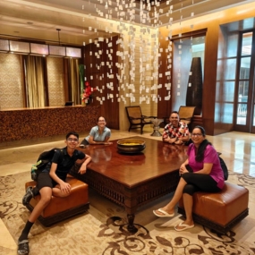 Four people seated around a large wooden table 