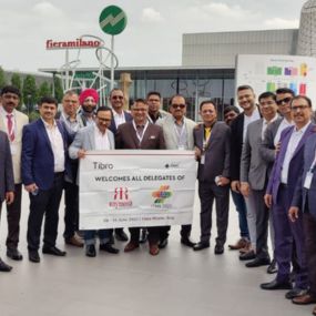 A group of delegates posing outdoors in front of a modern building