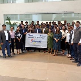 A large group posing with a banner at a Chemtek event.