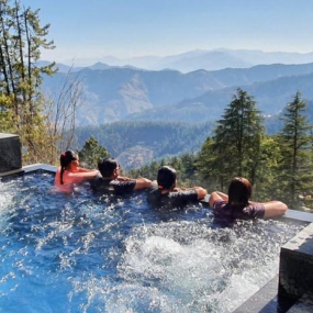 Group relaxing in a pool with stunning mountain views.