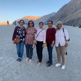Five women posing together in a scenic desert landscape.