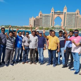 A group of men standing on a sandy beach