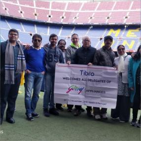 Group of people posing together on a soccer field.