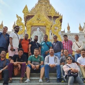 Group of people posing together fornt of the temple