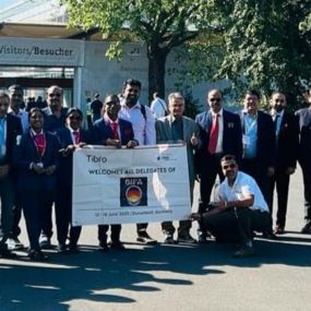 Group of people in formal attire posing outdoors in front of a building