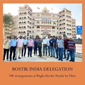 A group standing together, presenting a large sign or banner.