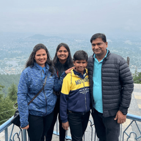 Family posing at a scenic viewpoint with a misty landscape backdrop.