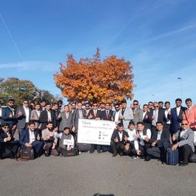 Tibro delegates gather under autumn tree during corporate event.