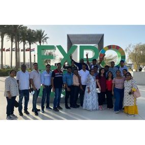 Group of people posing in front of an expo sign.