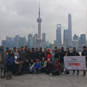 People standing together while presenting a large promotional banner.
