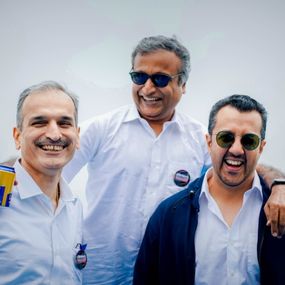 Three people in a frame laughing 