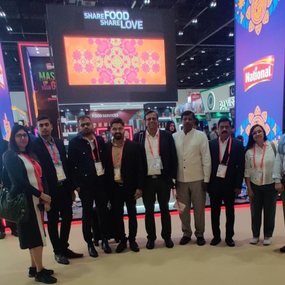 A group of professionals posing at an exhibition booth.