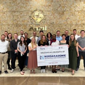 Group of people celebrating while presenting a large check