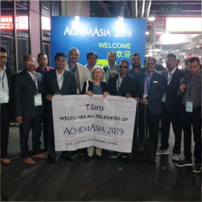 A group of people standing together in front of a large banner.