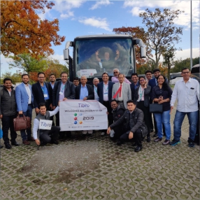 Group photo with Tabro banner in front of a tour bus, 2019.