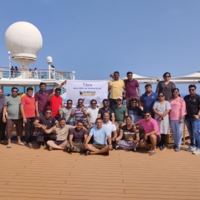 A group of smiling people holding a large banner