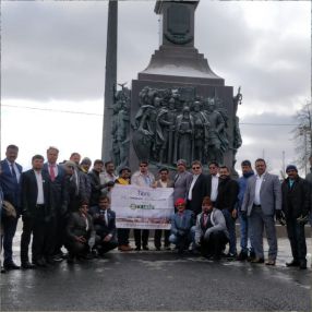 Group of people posing together in front of a historic monument