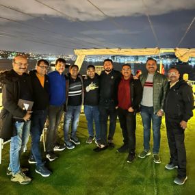 A group of people posing together at night on a deck 
