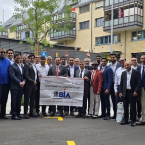 A group of delegates posing outdoors in front of a modern building