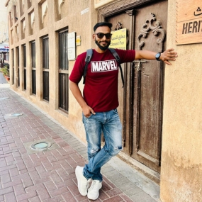 A man wearing a red "MARVEL" t-shirt poses