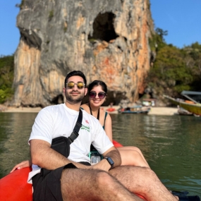 A couple sitting in a kayak on calm waters with a scenic